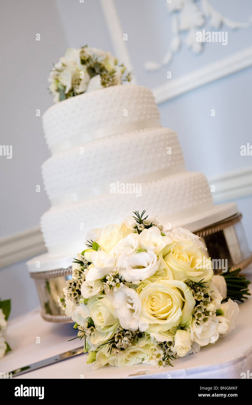 Wedding Cake and bride's floral bouquet Stock Photo