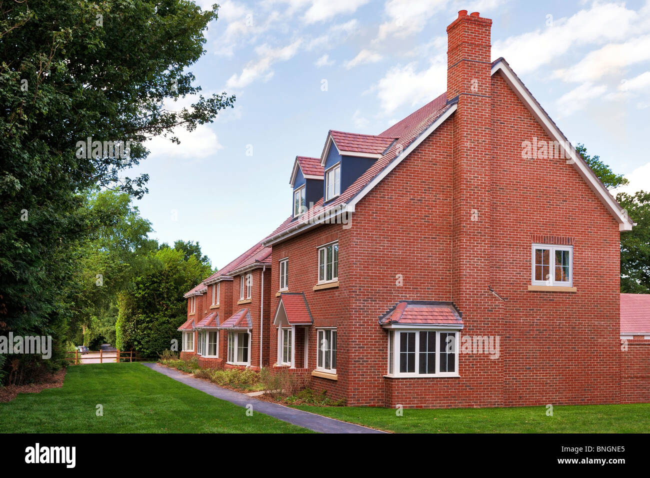 A row of empty new red brick houses on a modern UK housing estate development. Stock Photo