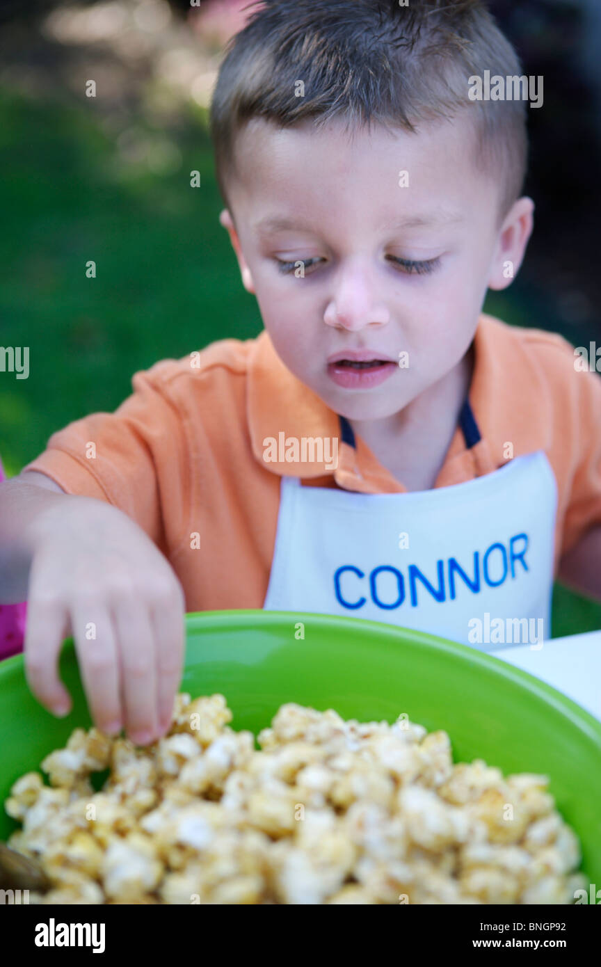 Young boy grabbing popcorn Stock Photo Alamy