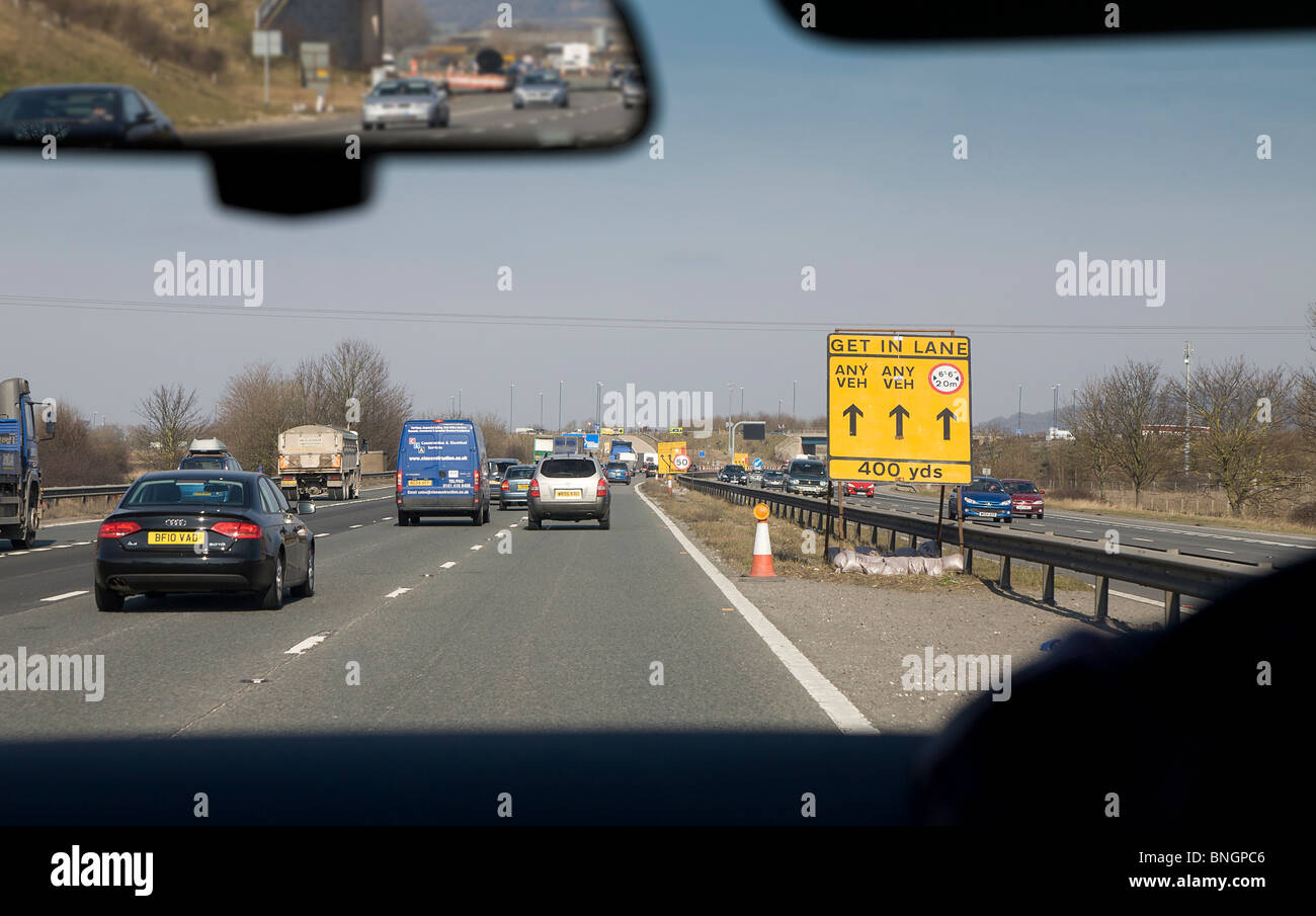 Traffic on motorway with road works sign, England UK Stock Photo