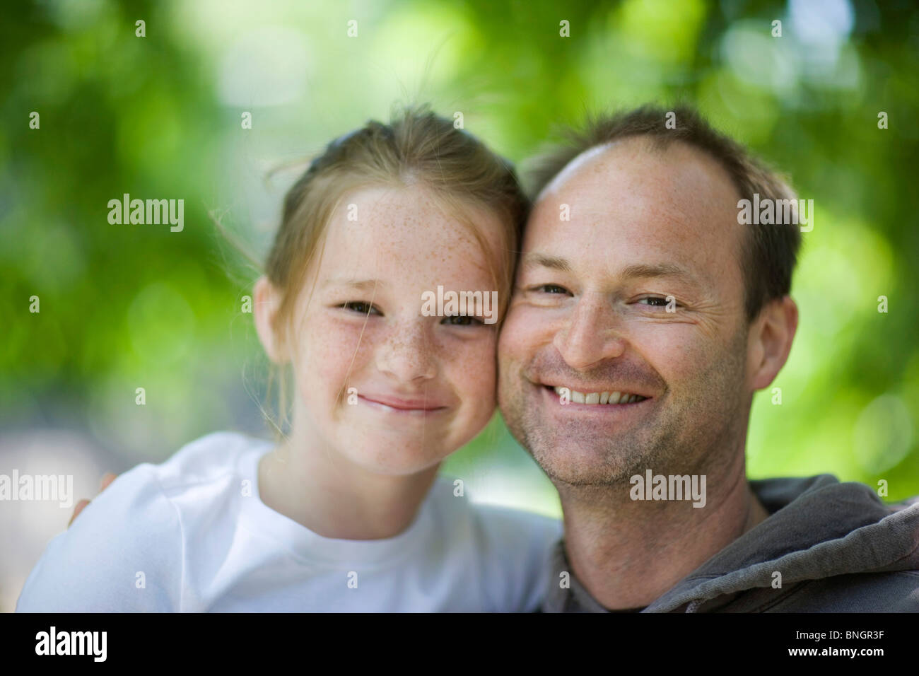 Portrait of a mid adult man smiling with his daughter Stock Photo - Alamy
