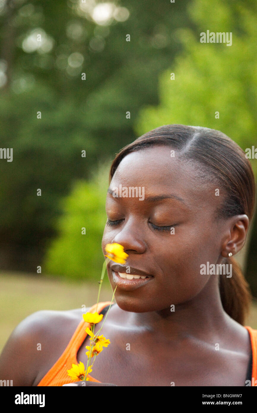 Young woman smelling a flower Stock Photo - Alamy