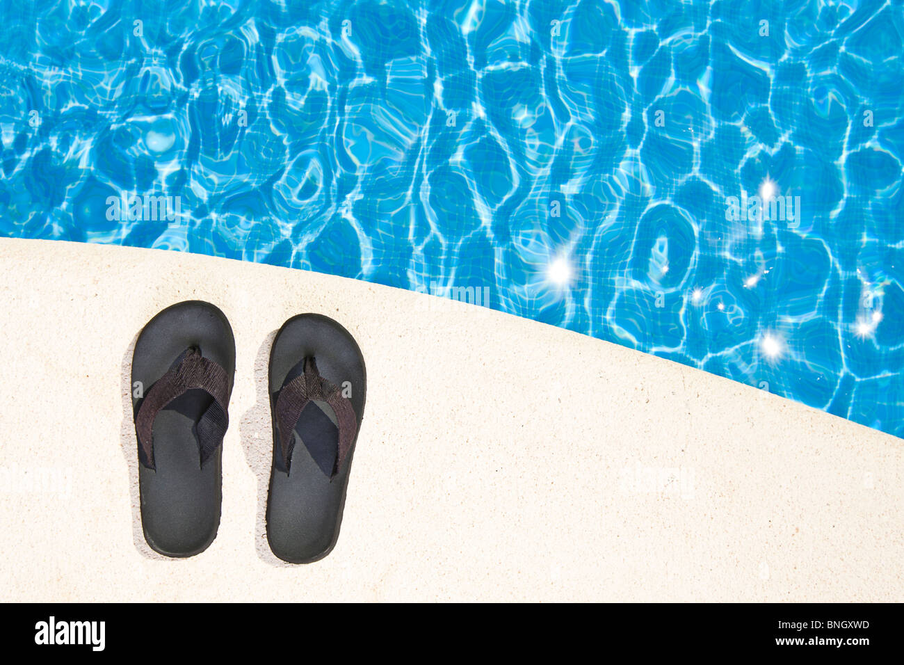 Shot of a Pair of Flip Flops next to the Pool Stock Photo