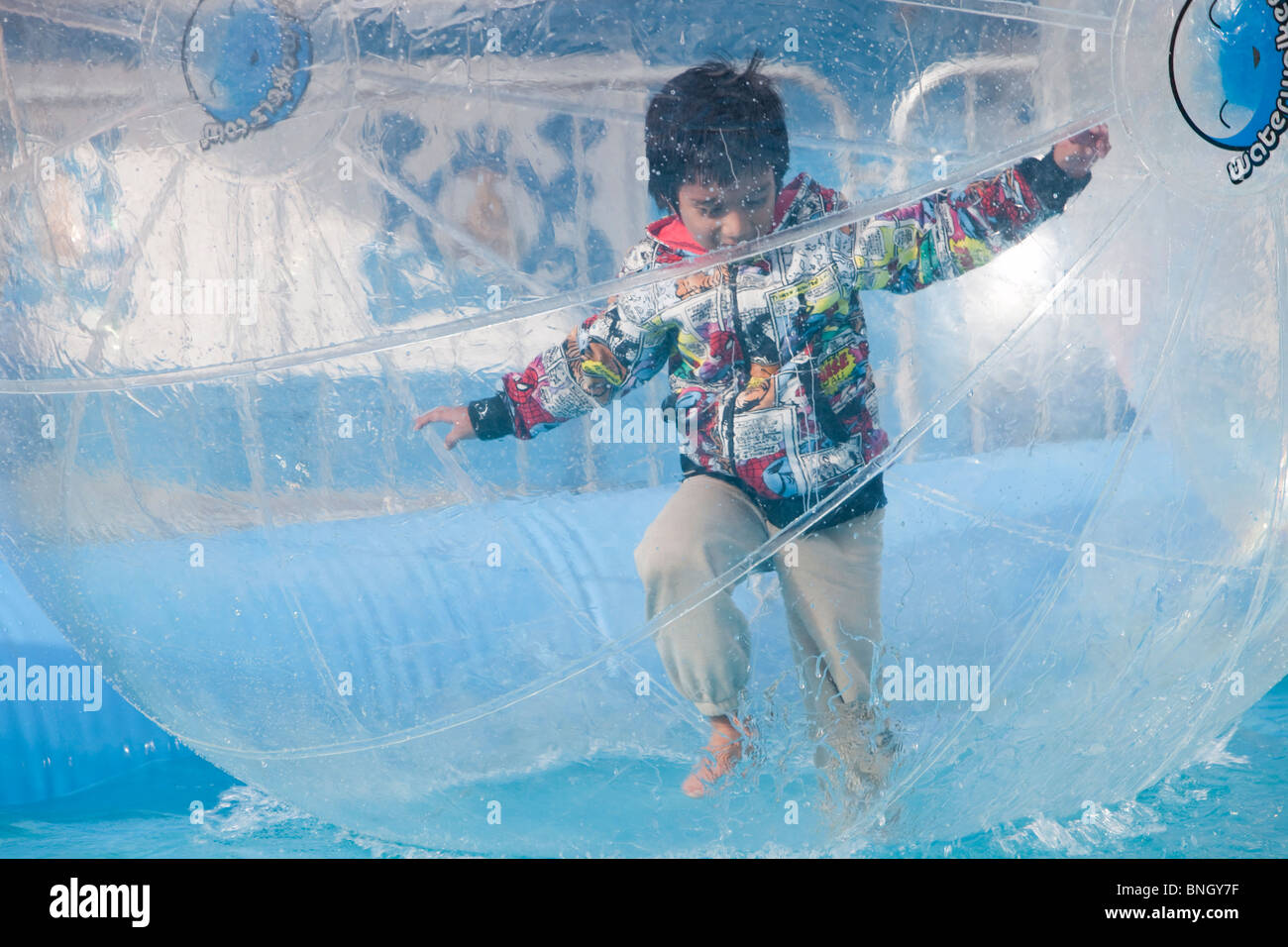 Children playing in water walkers on Llandudno Pier, North Wales Stock