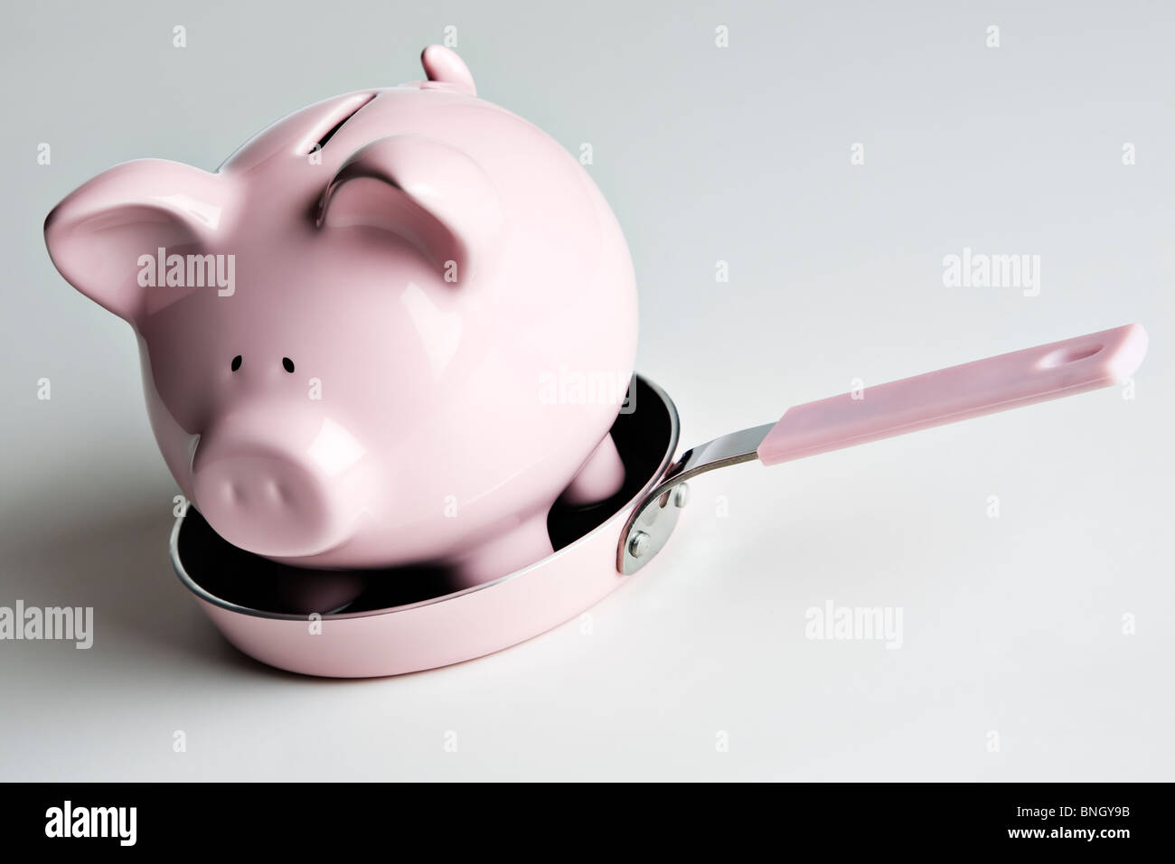 Pink piggy bank in a pink frying pan Stock Photo