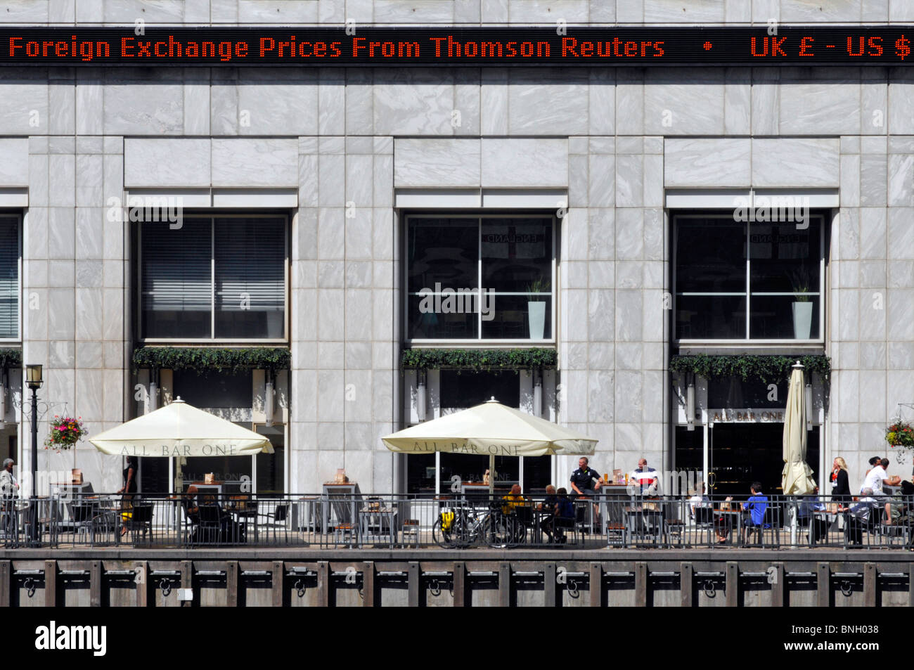 Canary Wharf Thomson Reuters electronic Foreign Exchange sign above outdoor bar Stock Photo