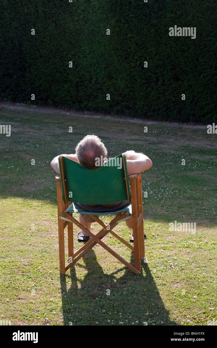 Elderly Man Asleep In A Garden Chair In The Sun Kent Uk Stock
