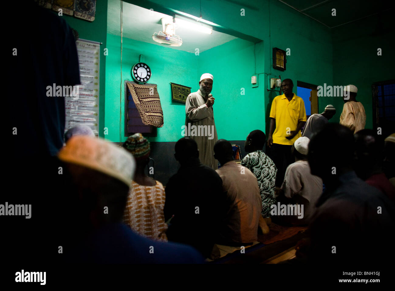 A local imam speaks to mosque attendees about an upcoming national polio immunization exercise after evening prayers at a mosque Stock Photo