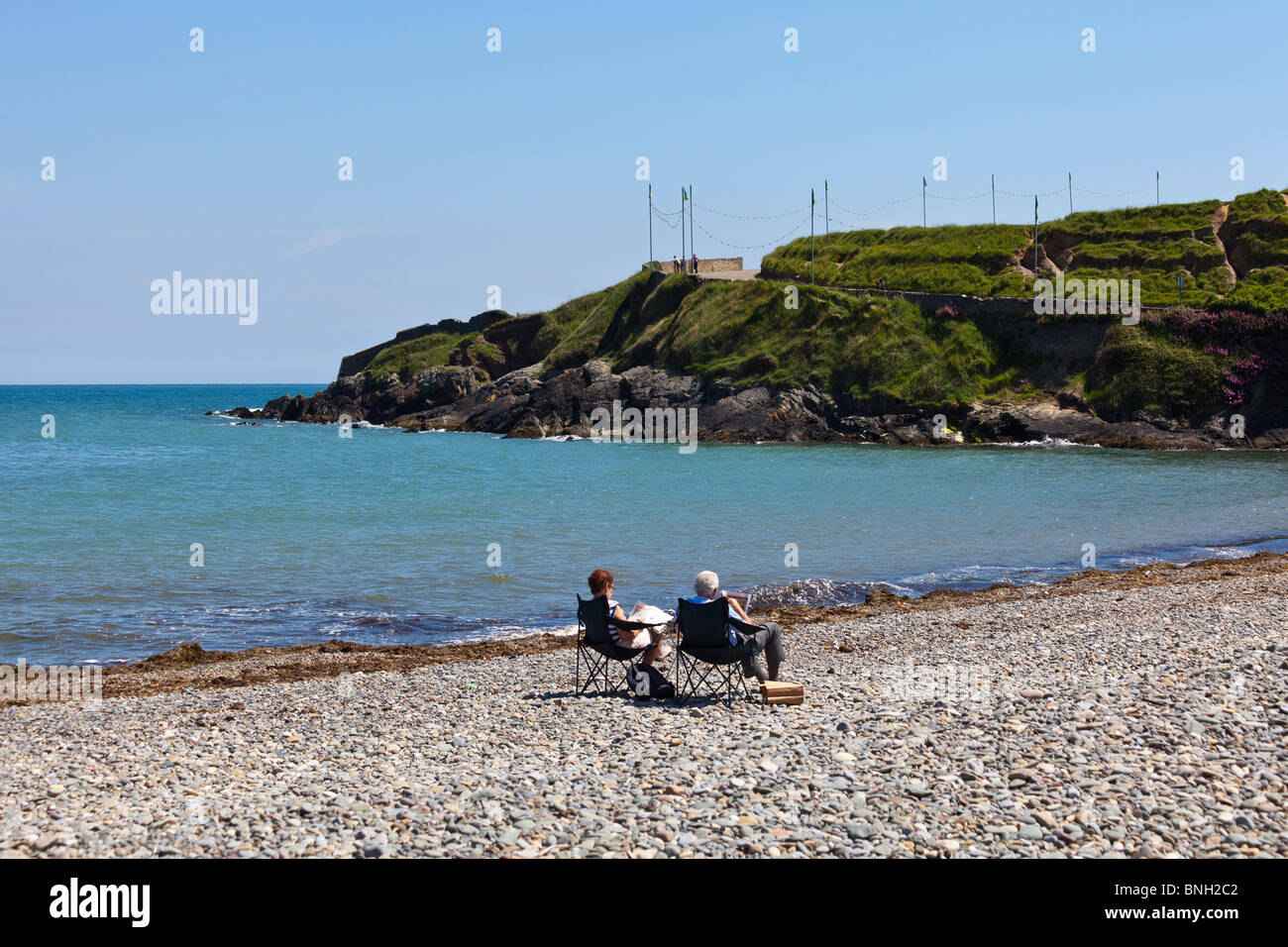 couple reading newspapers on deserted beach at  summer in Bray, near Dublin, Ireland Stock Photo