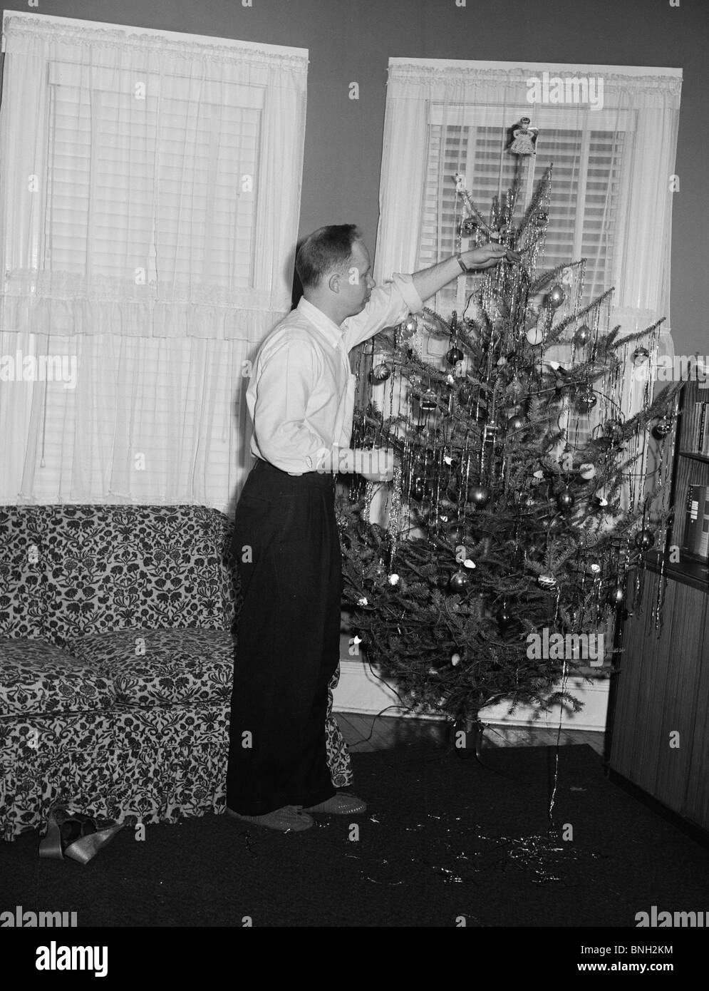 Side profile of a mid adult man decorating a Christmas tree Stock Photo