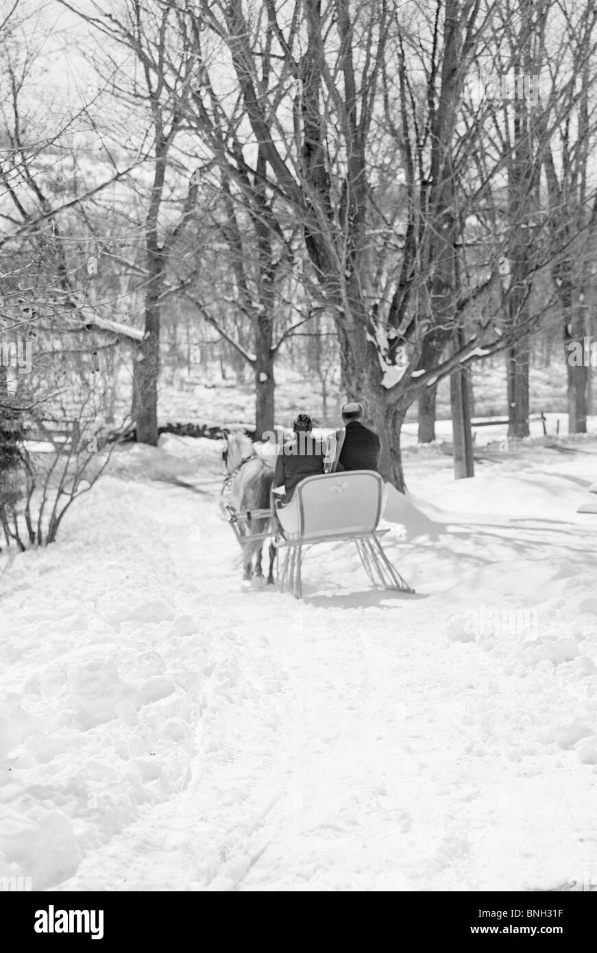 Rear view of two people sitting in a sleigh pulled by horse, Vermont ...