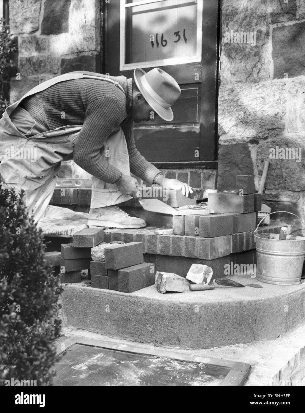 Side profile of a man laying bricks for a doorstep Stock Photo