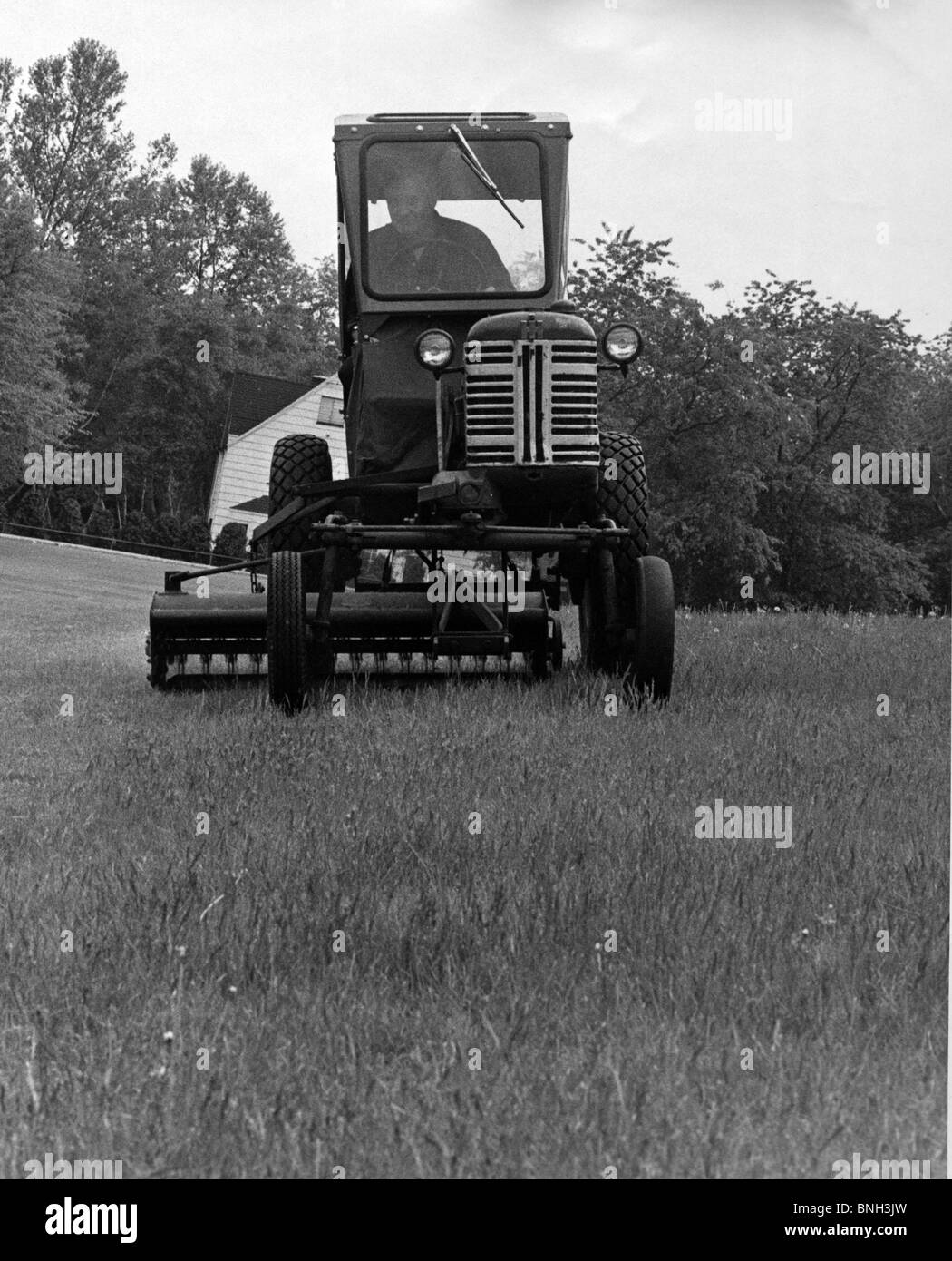 Farmer driving a tractor in a field Stock Photo