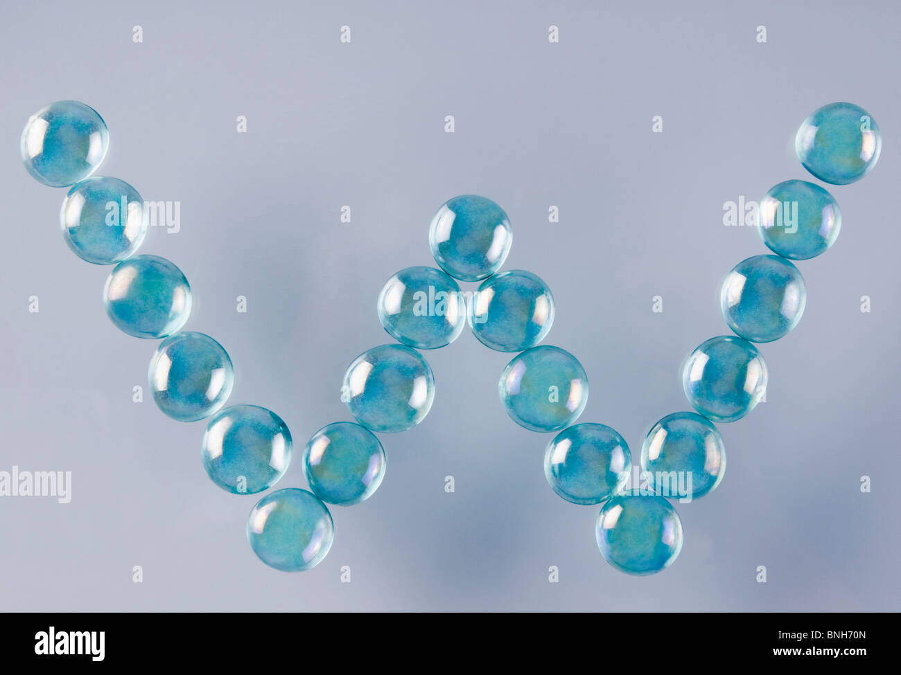 Close-up of marble balls arranged in the shape of letter W Stock Photo