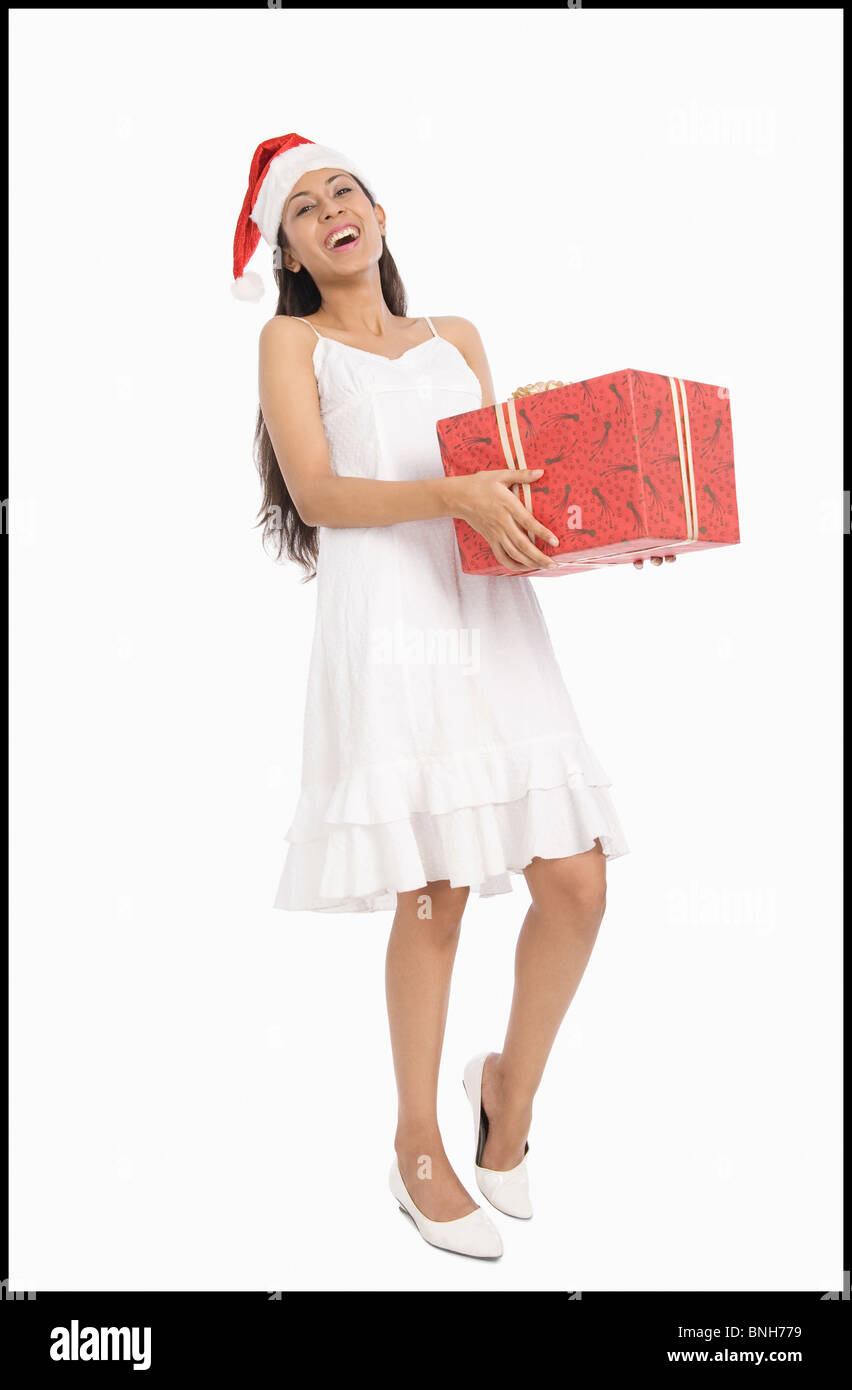 Woman wearing a Santa hat and holding a Christmas present Stock Photo ...