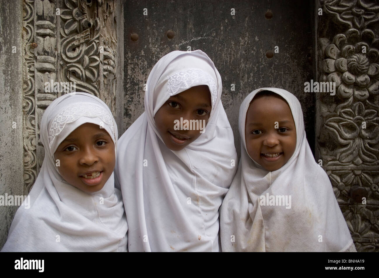 Young girls wearing white head scarves, Stone town, Zanzibar, Tanzania Stock Photo
