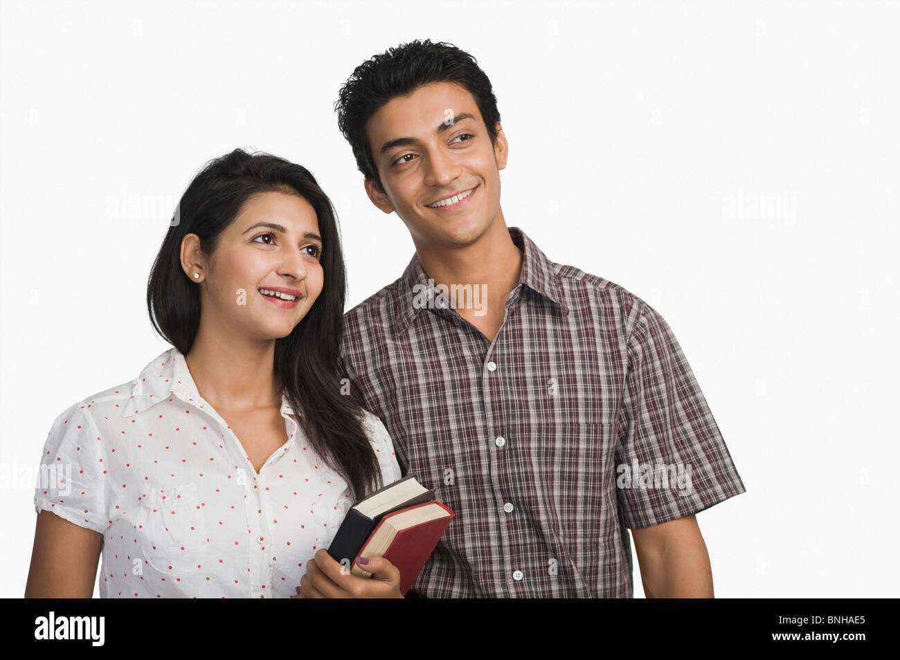 College students holding books and smiling Stock Photo - Alamy