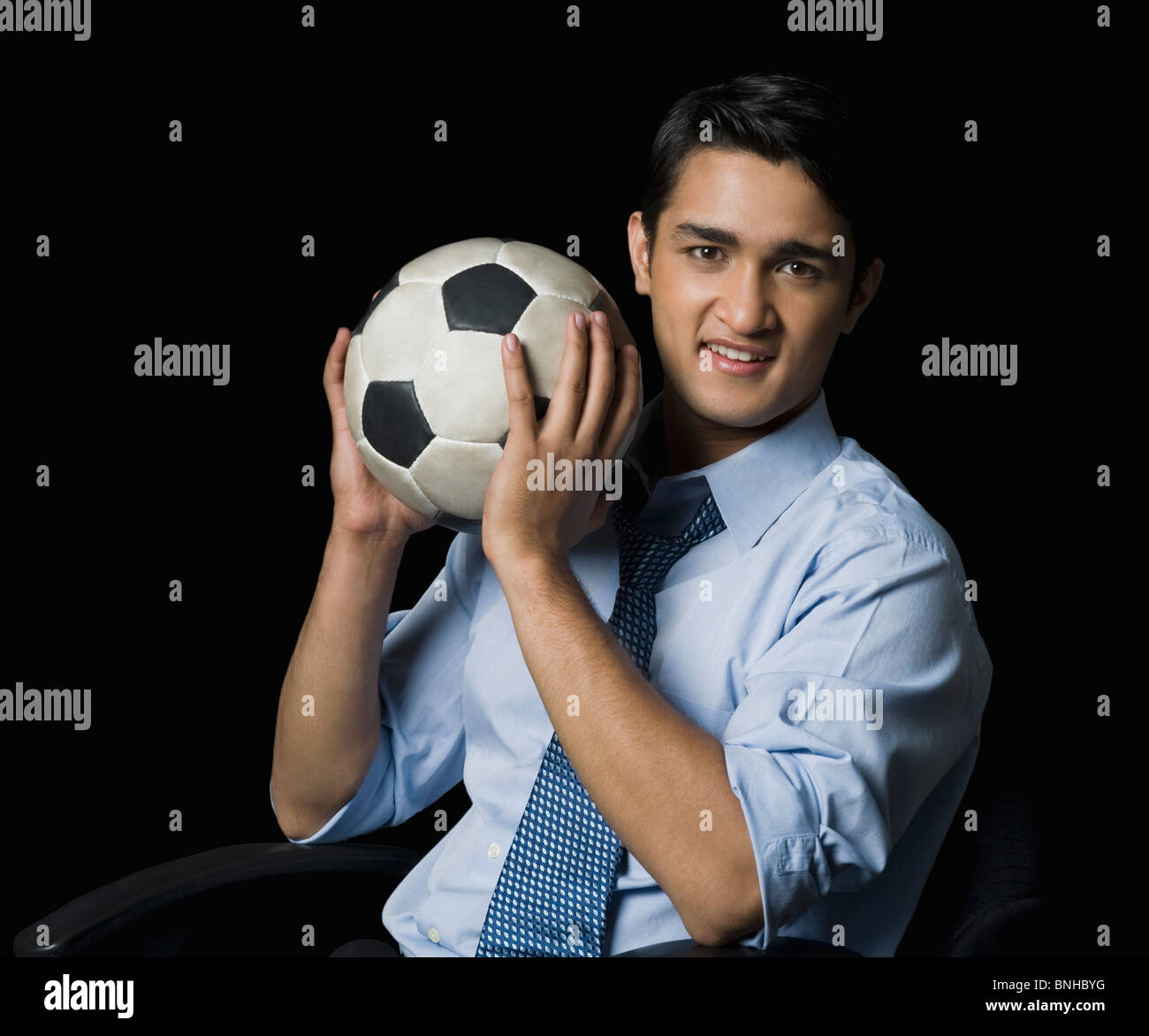 Businessman holding a soccer ball Stock Photo - Alamy