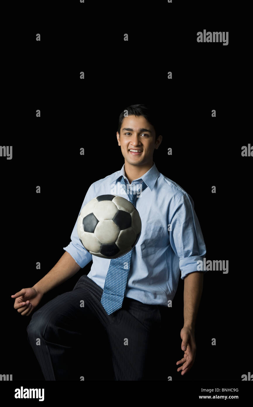 Businessman playing with a soccer ball Stock Photo - Alamy