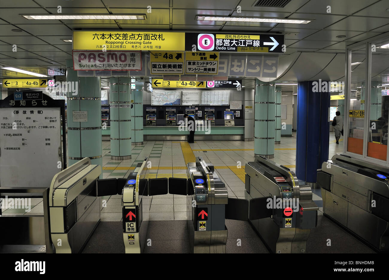 Ticket gates and single business man at ticket vending machine at Tokyo`s Roppongi subway station (Japan) Stock Photo