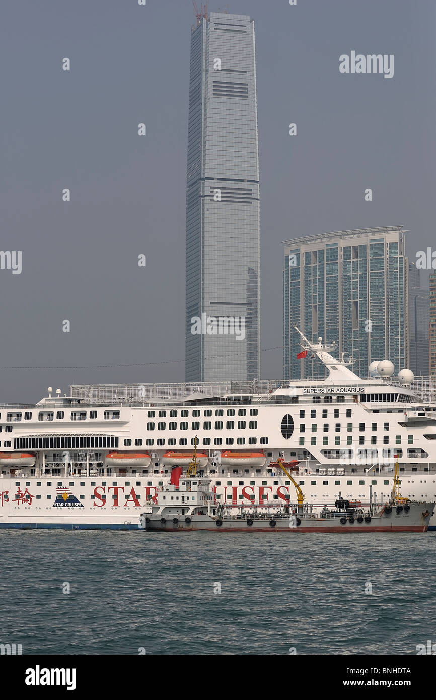 Cruise ship docking at Hong Kong's 'Ocean Terminal' with 'ICC' (International Commerce Center) in background (Hong Kong, China) Stock Photo