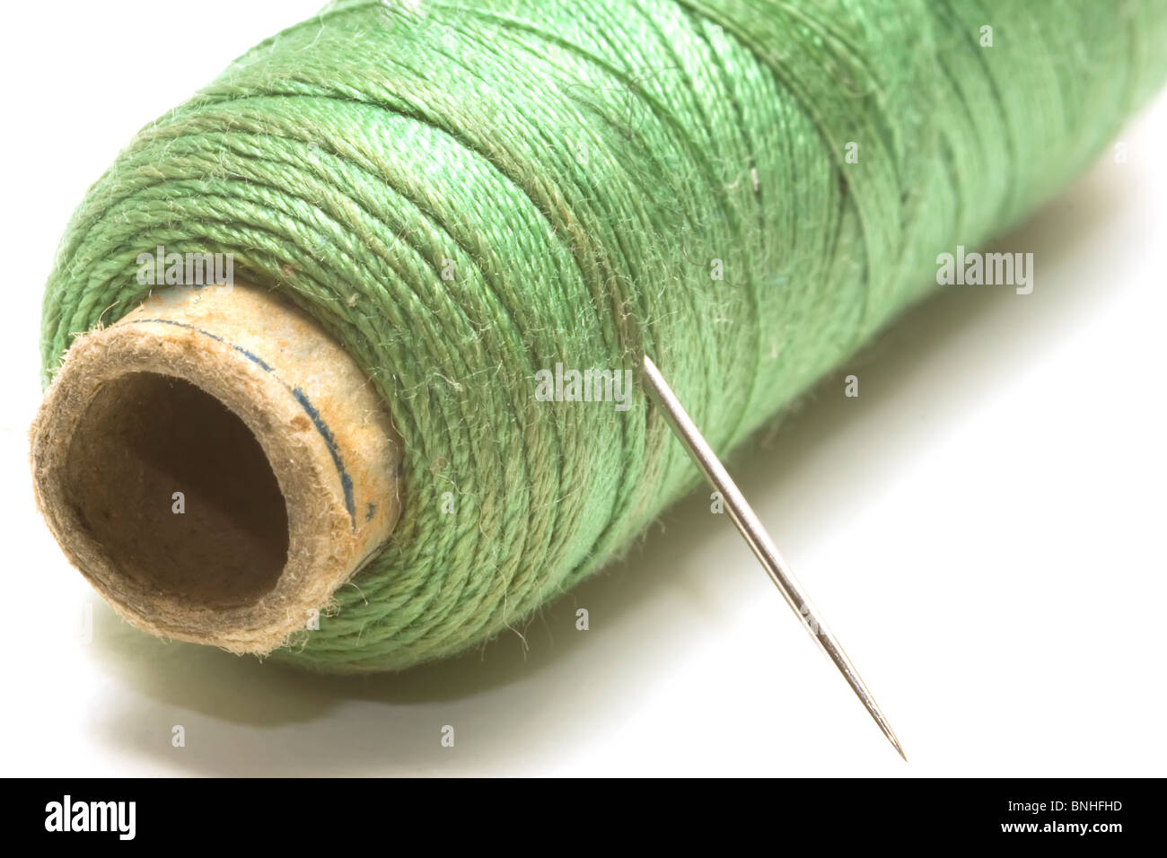 Green sewing thread and a needle sharp Stock Photo Alamy