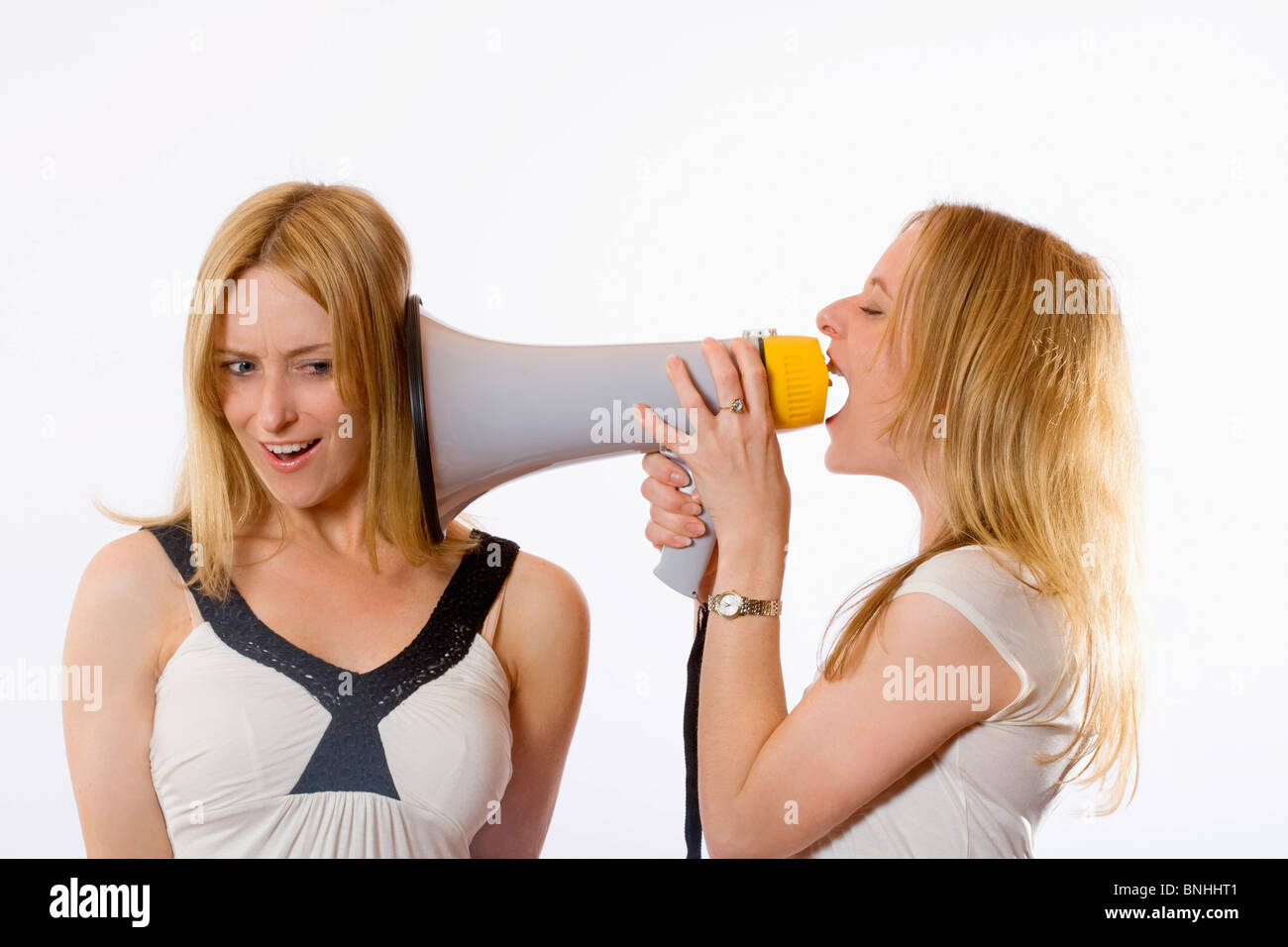 Twin Sisters Megaphone 20-30 years Acoustic Action Adult Adults Background Blond hair Bossy Communicate Communication Control Stock Photo