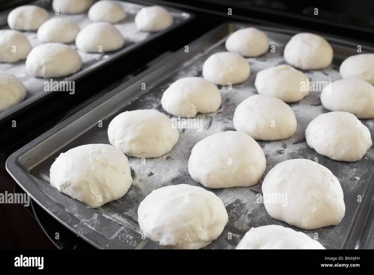Dough buns on baking sheet Stock Photo
