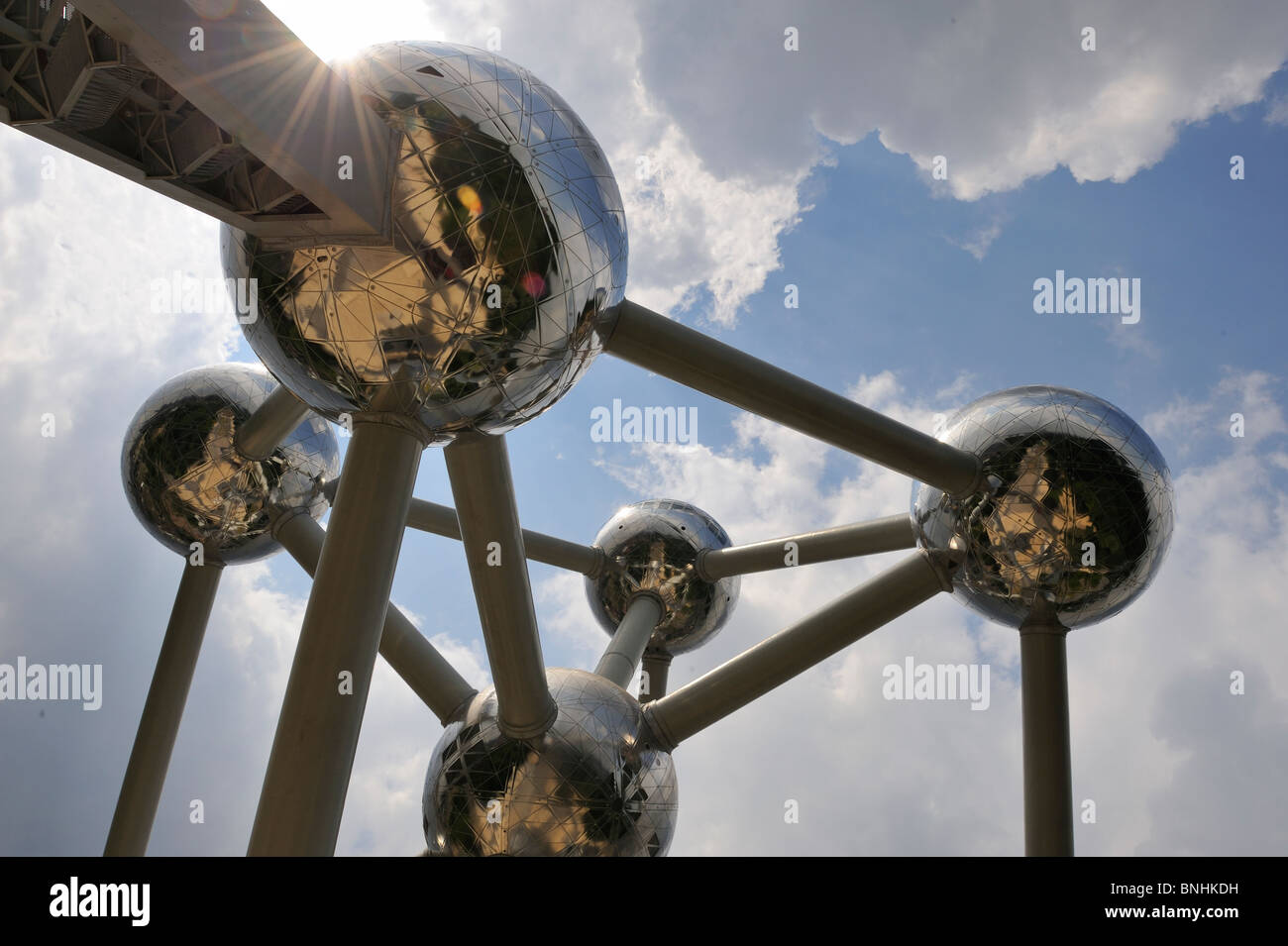 Atomium Brussels Belgium tourist attraction iconic symbol silver balls. Dramatic sky sun flare clouds Stock Photo