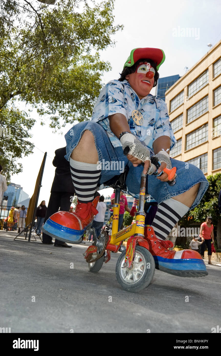 Clown riding a miniature bike during a clown parade in Mexico city with clowns from several countries Stock Photo