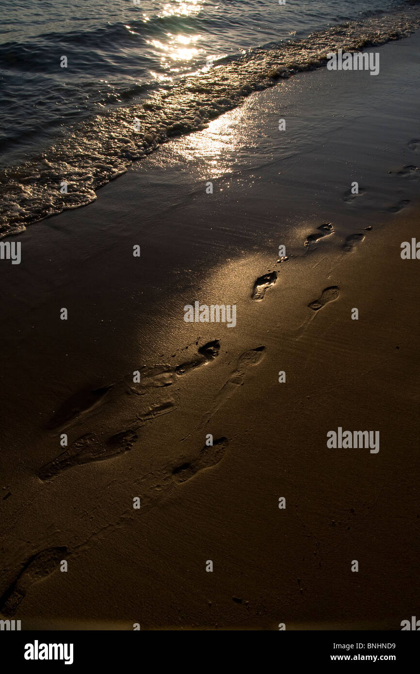Foot Steps in the Sand as the sunsets on Pefkos Beach, Rhodes, Greece. Stock Photo