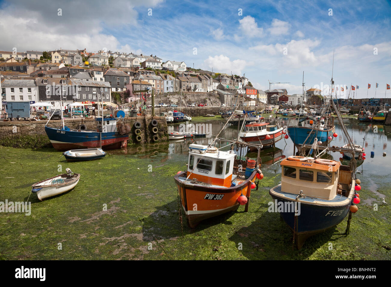 Mevagissey harbour, the tide is out leaving the boats beached in dry dock Stock Photo