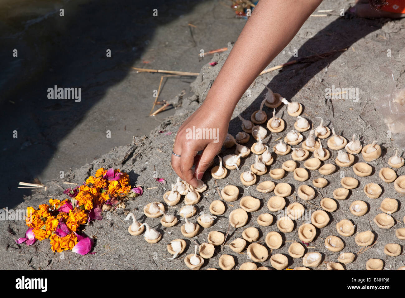 Woman making a ritual offering (puja). Ganges river. Allahabad. India Stock Photo