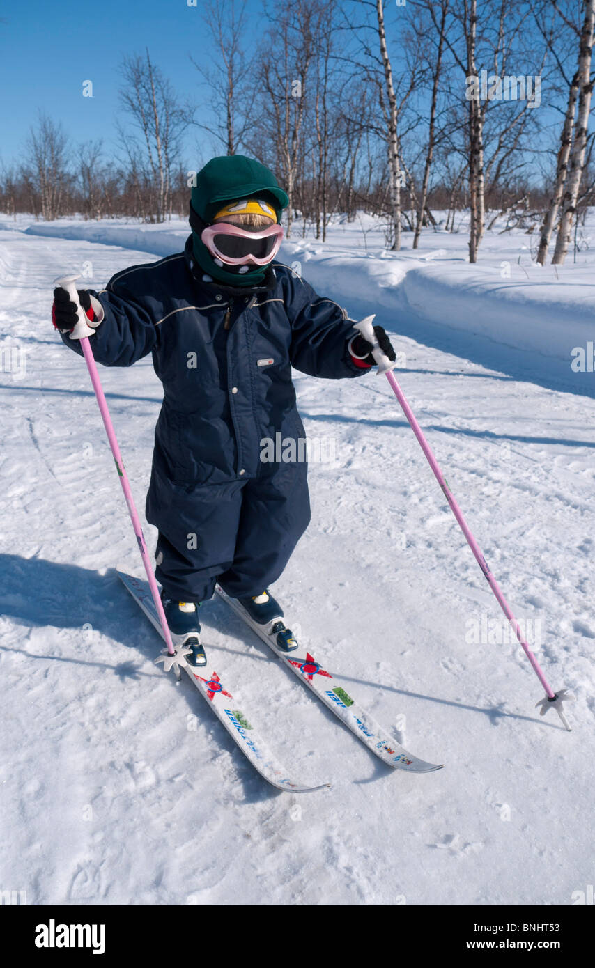 A three year old skiing girl makes her way at the frozen Kaalasjärvi lake at Kiruna, Lapland, Northern Sweden. Stock Photo