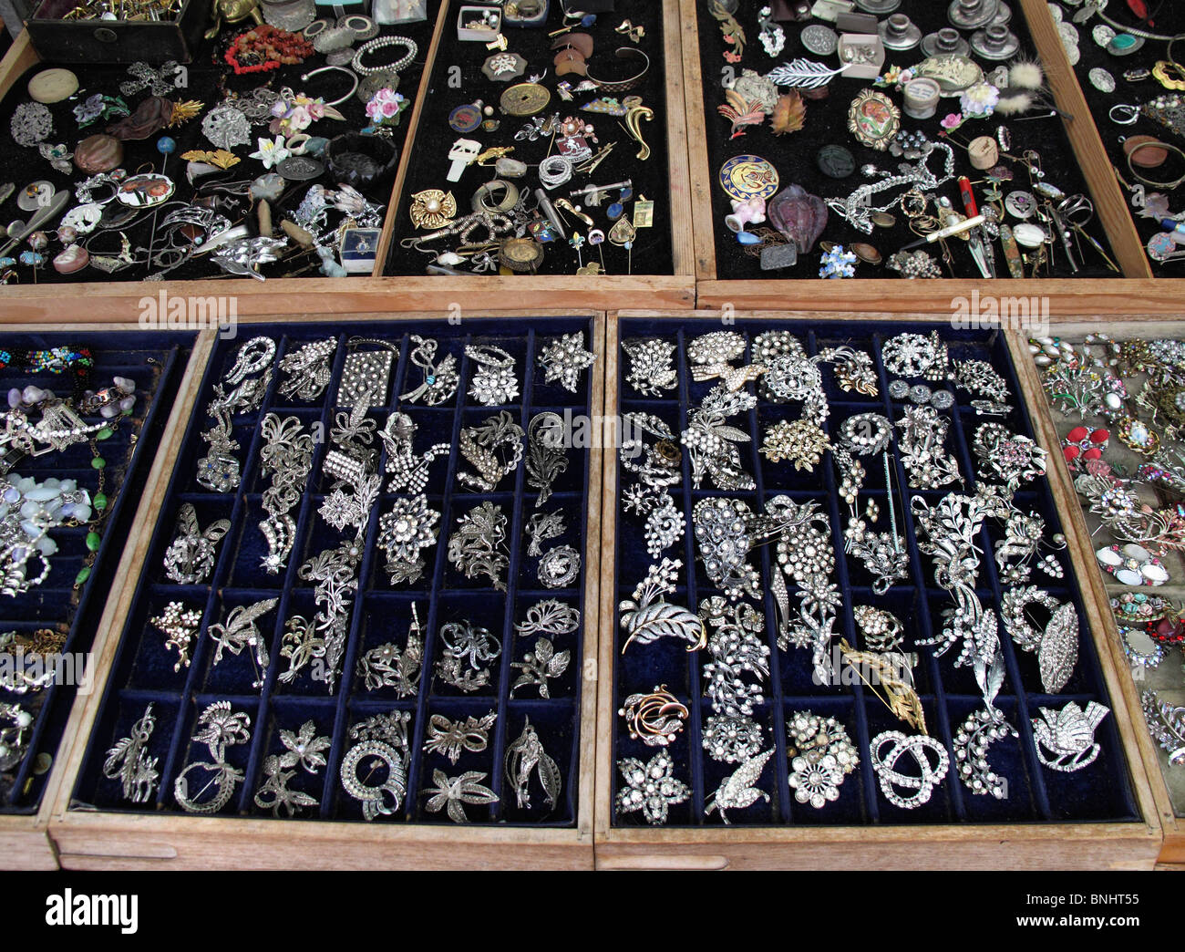 Selection of second hand jewelry on trays in antique market Stock Photo