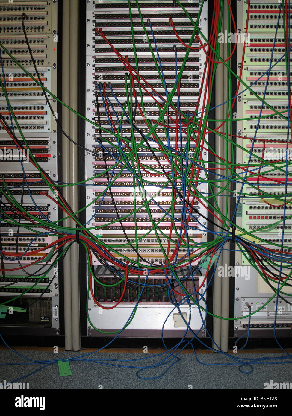 Coloured wires extending from tall computer servers Stock Photo