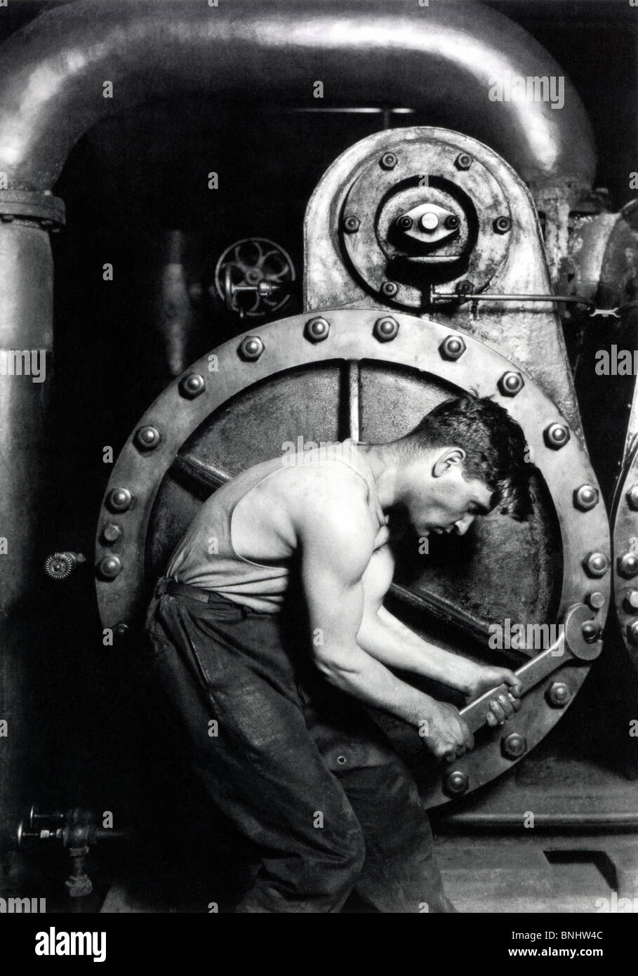 Powerhouse mechanic by Lewis Hine Power house mechanic working on steam pump 1920 industry mechanics work worker man machine Stock Photo