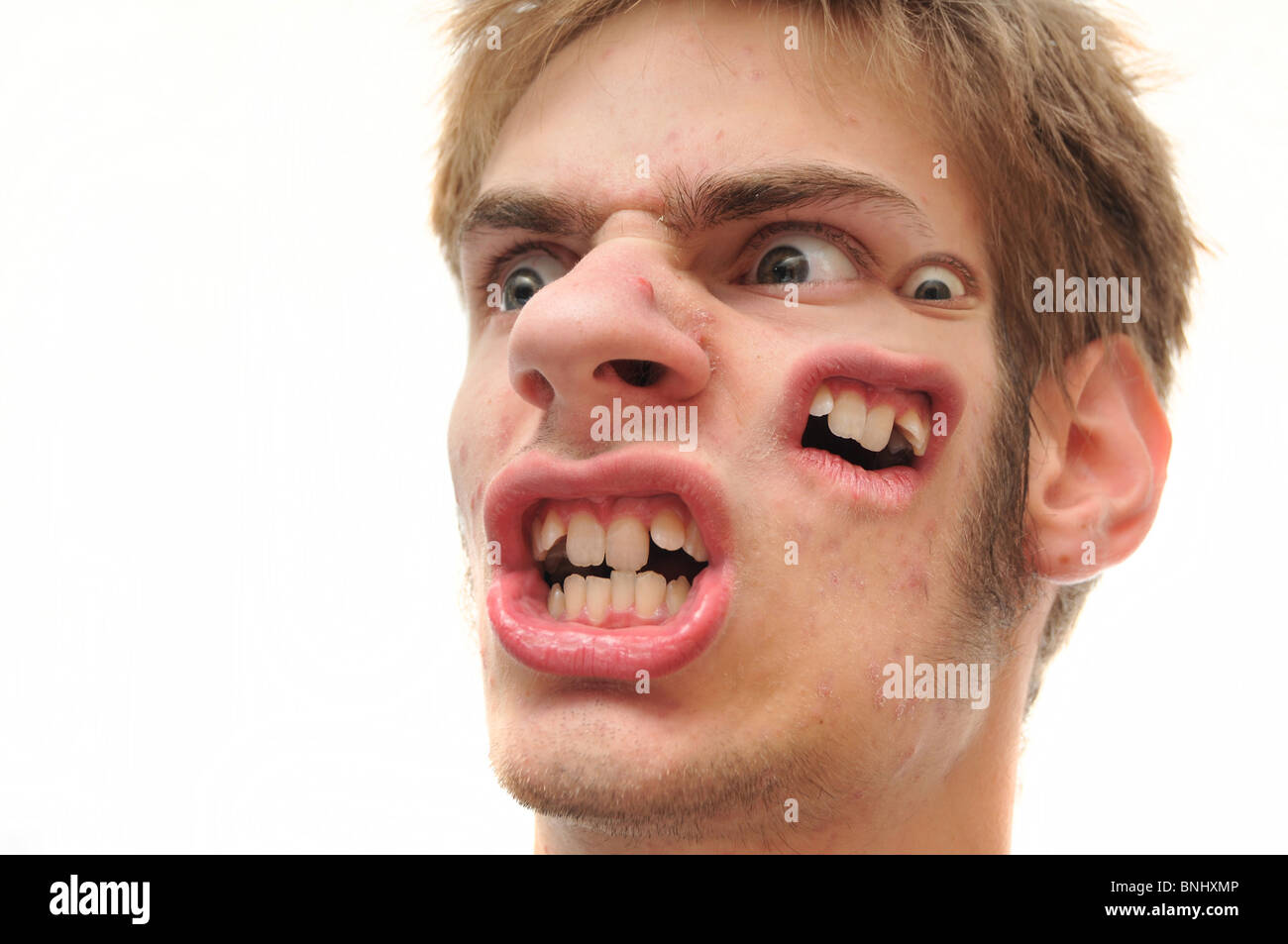 An ugly angry man with another face on the side of his main face isolated on white. Stock Photo