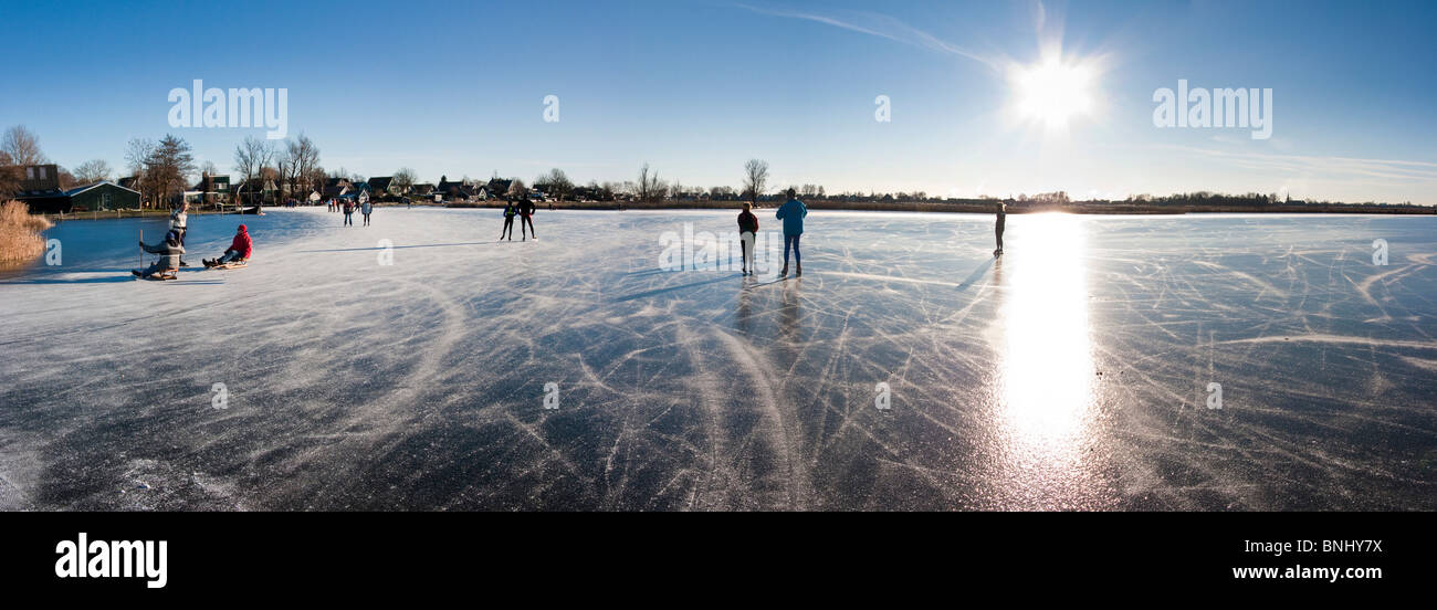 The Netherlands Holland landscape scenery nature winter canal channel Gracht canal ice skating people froze Stock Photo