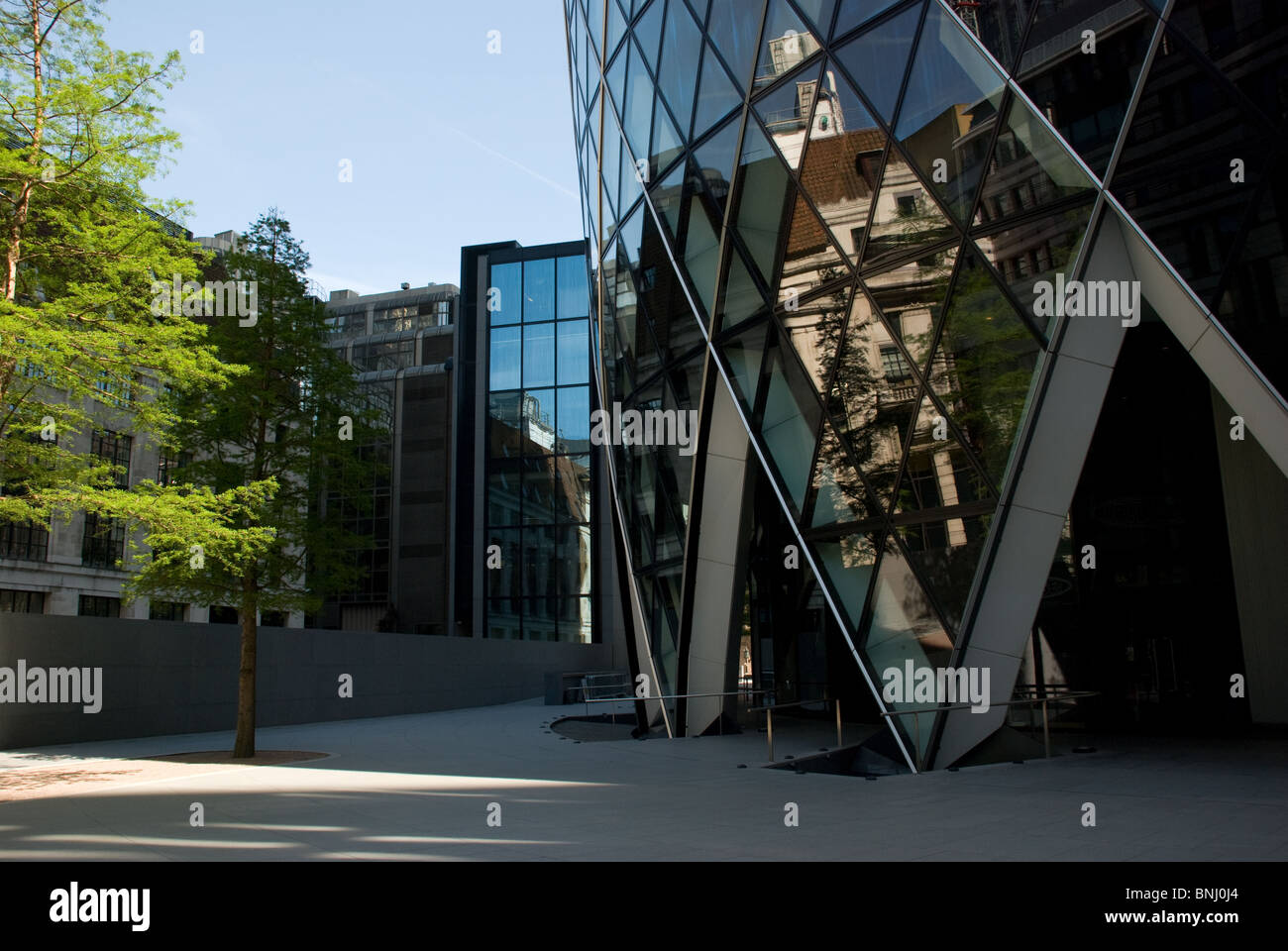 The entrance to Sir Norman Fosters 30 St Mary Axe, also known as the Gherkin, with tree Stock Photo