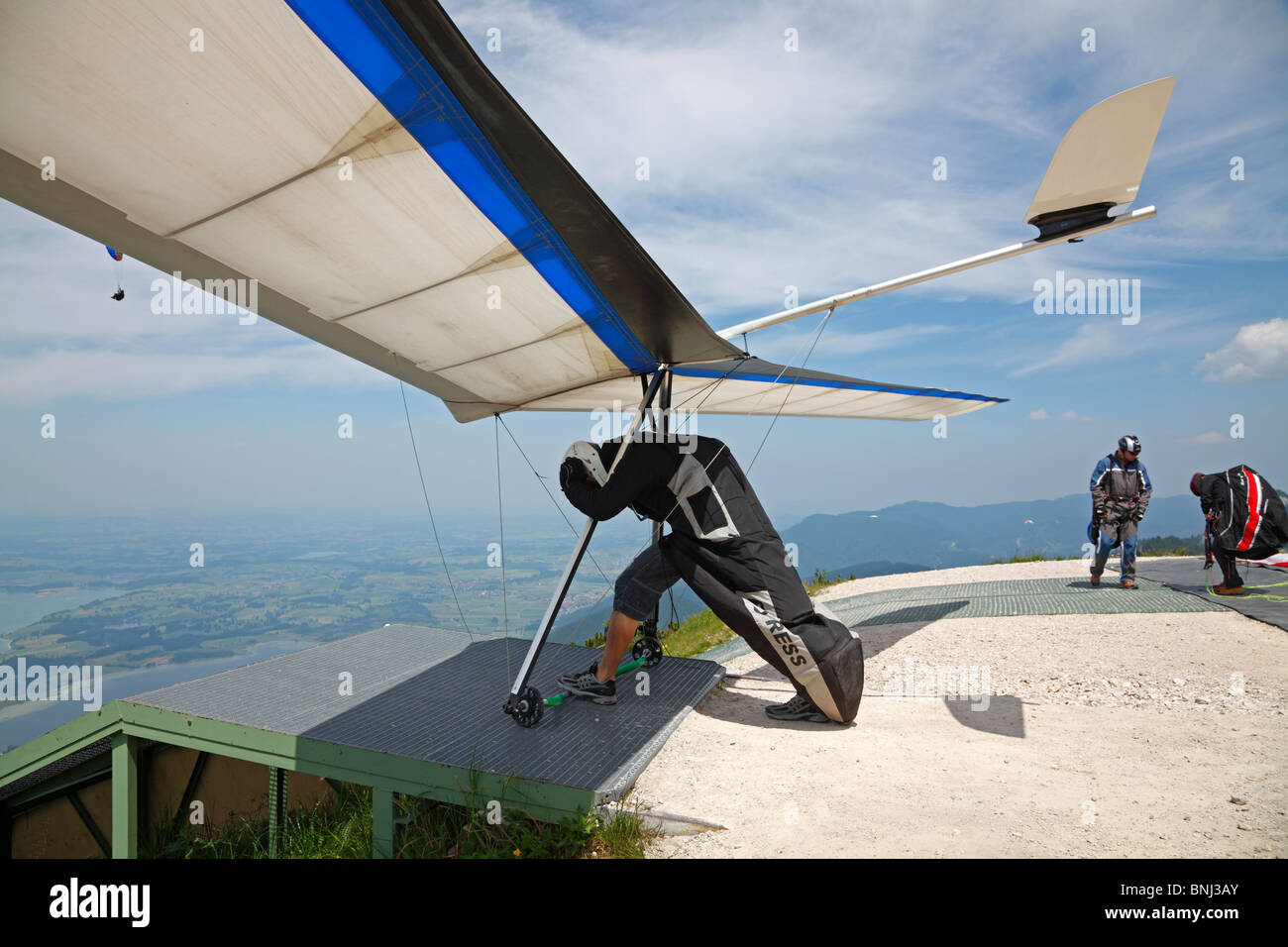 A hang glider is waiting for the right time for take-off on the summit of Tegelberg in Schwangau in Bavaria, Germany. Stock Photo