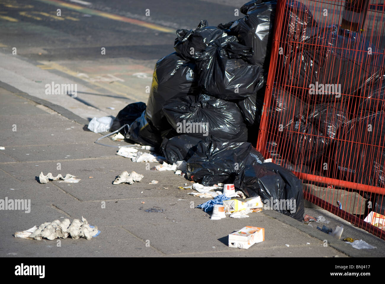 Bags of rubbish (refuse, garbage, household waste) on the pavement