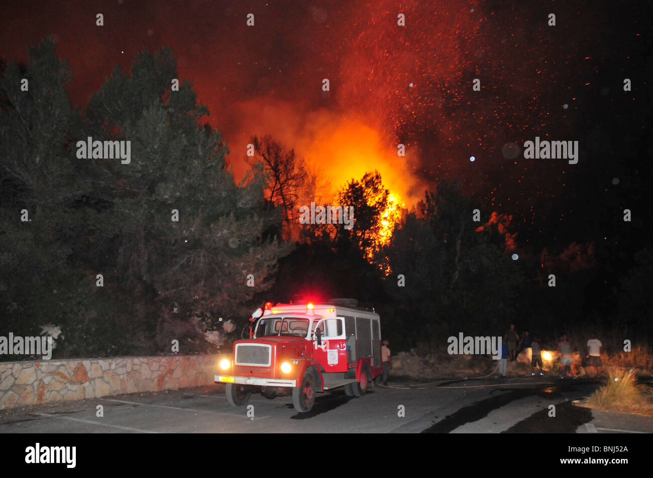 Israel, Haifa Carmel Mountain Forest, fire fighter fighting the flames at night Stock Photo