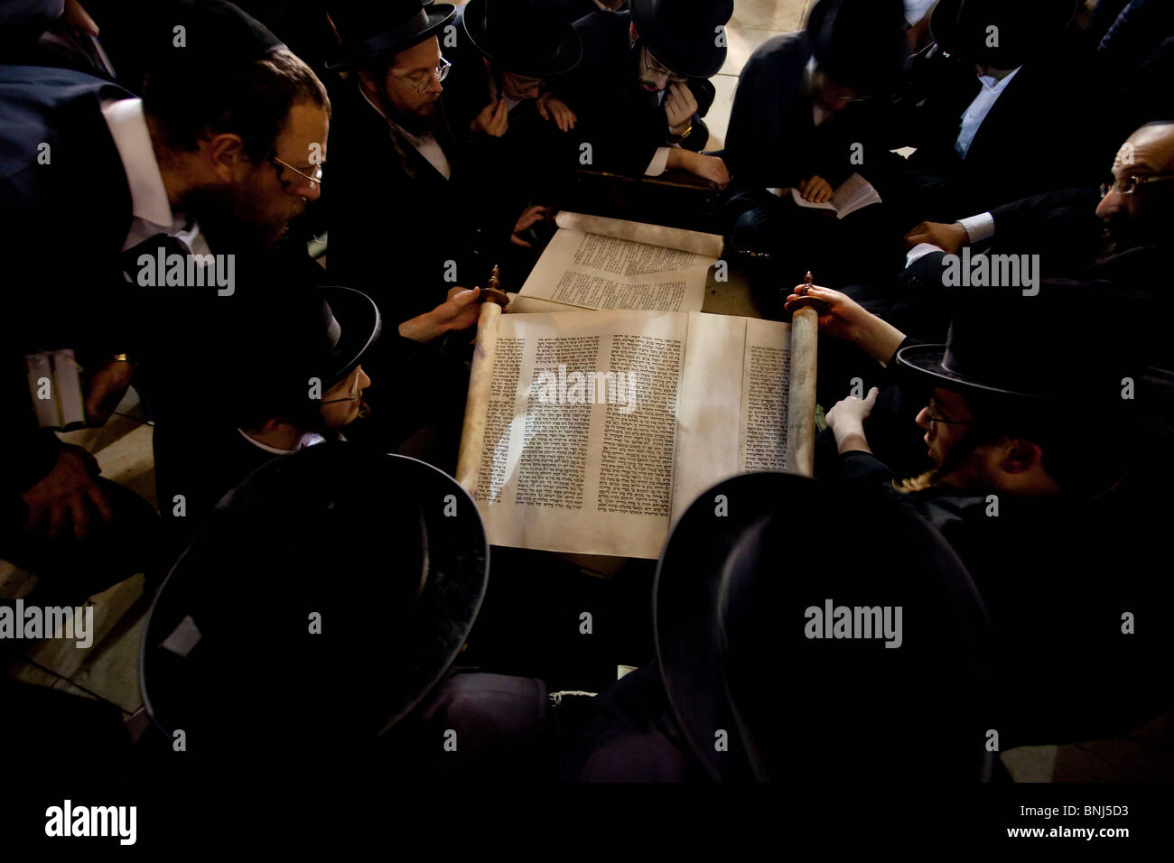 Ultra Orthodox Jews read from a Torah scroll the biblical Book of Lamentation on Tisha Beav annual fast day in the Wailing Wall East Jerusalem Israel Stock Photo