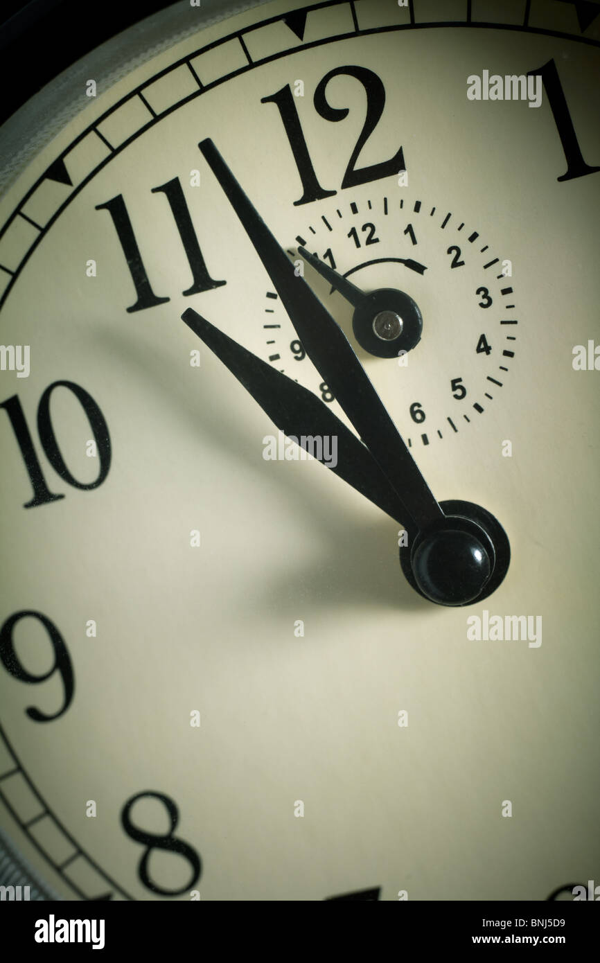 Hands pointing to midday on clock face Stock Photo