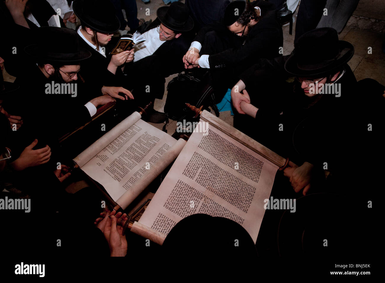 Ultra Orthodox Jews read from a Torah scroll the biblical Book of Lamentation on Tisha Beav annual fast day in the Wailing Wall East Jerusalem Israel Stock Photo