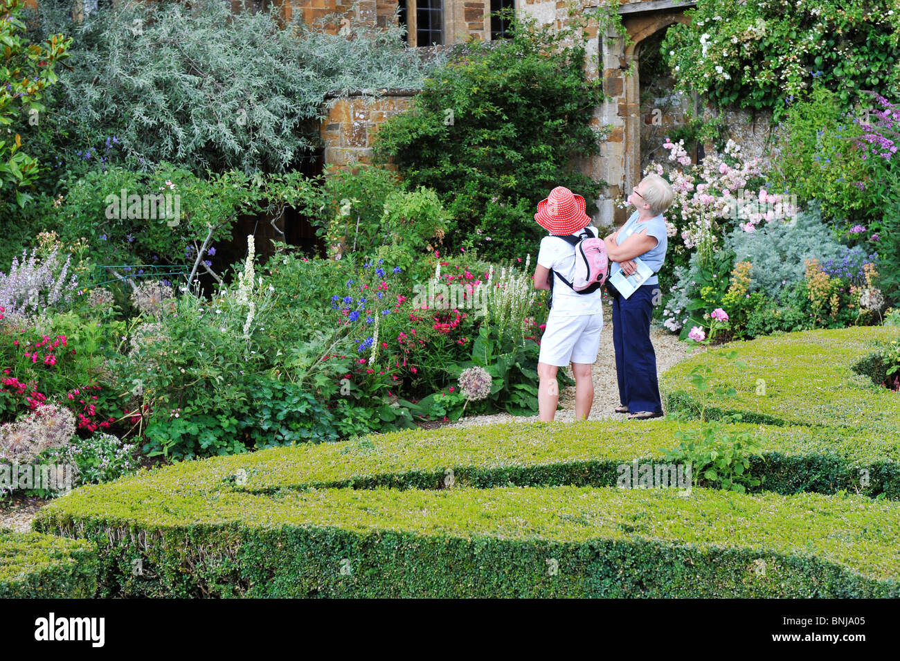 Visitors in the gardens of historic Broughton Castle near Banbury in Oxfordshire. Royalist stronghold of the English civil war Stock Photo