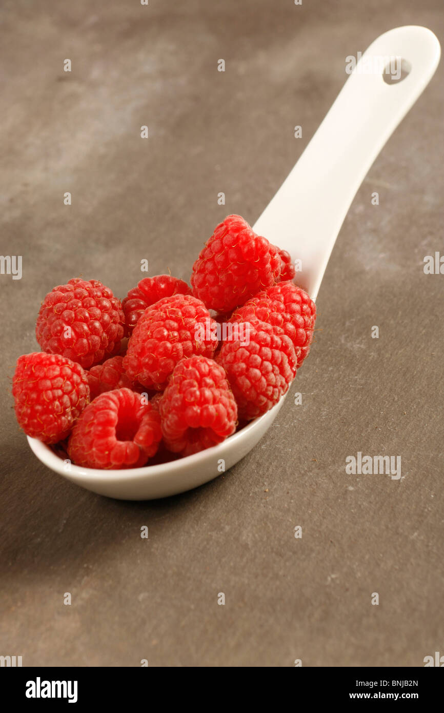 Raspberries on porcelain spoon Stock Photo