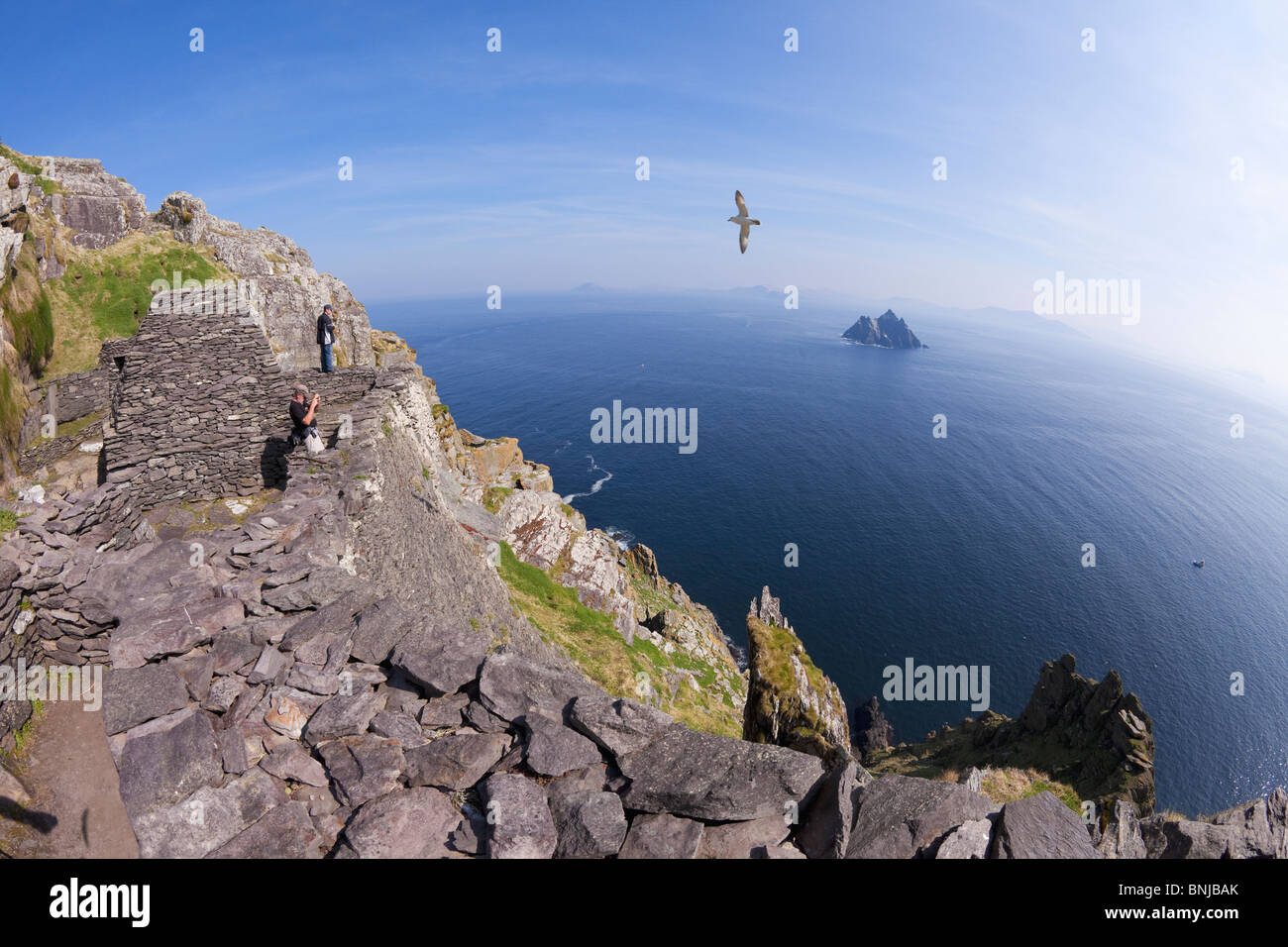 Visitors admire celtic monastic monastery Skellig Michael looking to Little Skellig County Co. Kerry Ireland Stock Photo