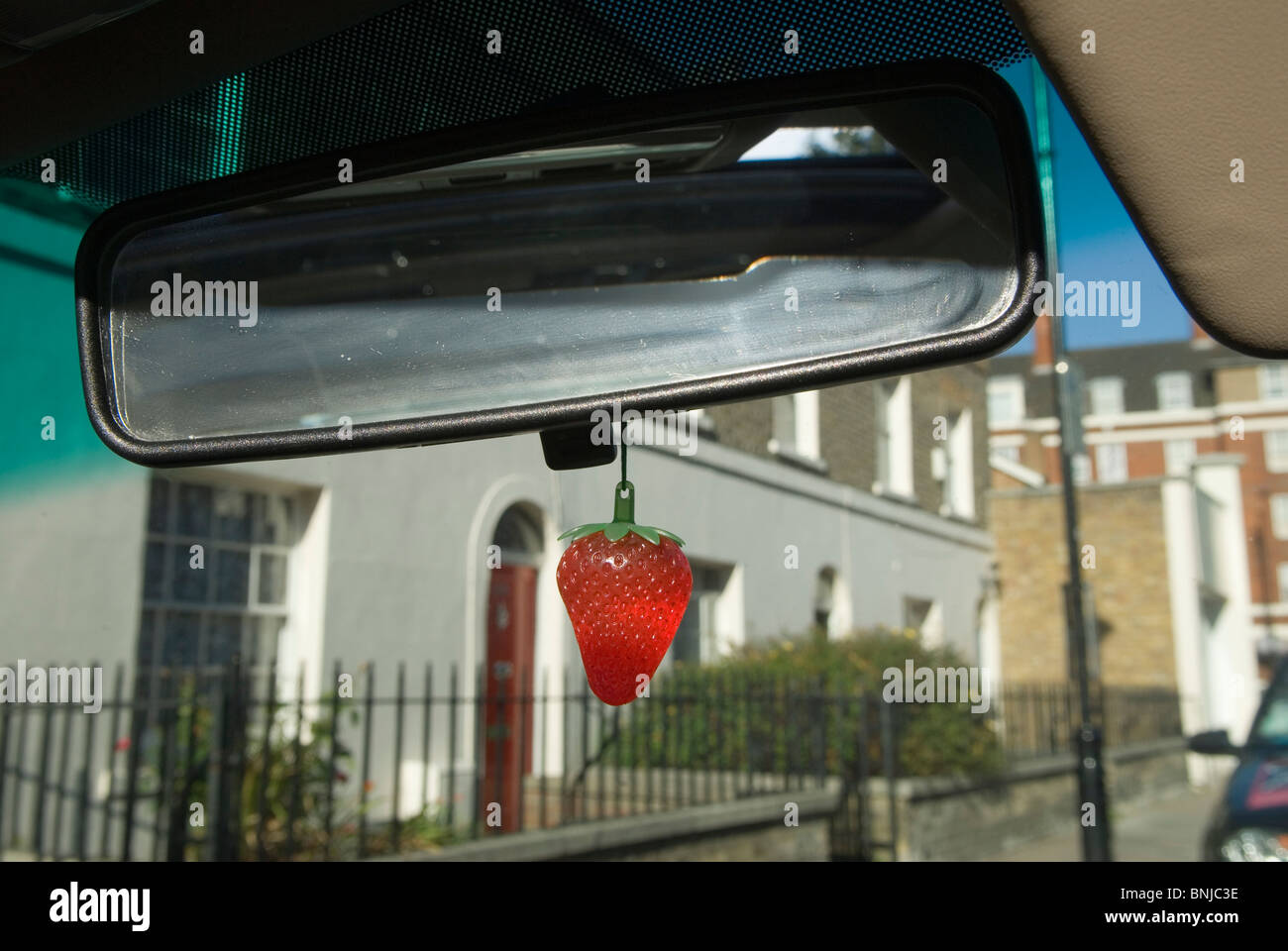 Car air freshener hanging from internal rear view drivers car mirror